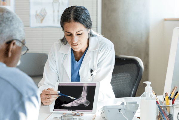Orthopedist discusses senior patient's foot x-ray